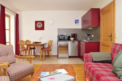 a living room with a couch and a kitchen at Ferienwohnungen Wendelstein in Bad Feilnbach