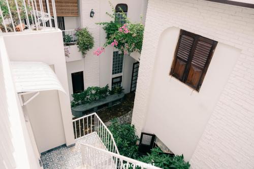 an external view of a white building with a window at DƯỚI TÁN CÂY homestay in Tây Ninh