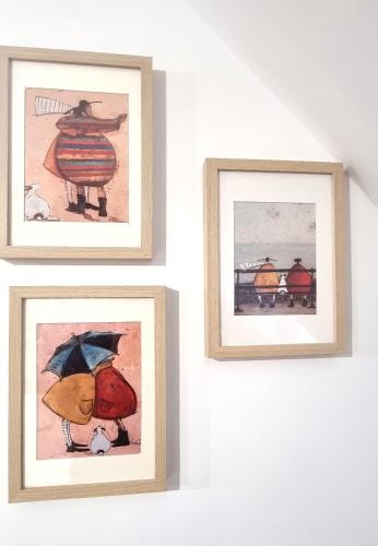 three framed pictures hanging on a white wall at La maison GUILLAUME in Falaise