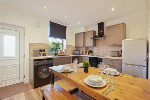 a kitchen with a wooden table with plates on it at Beighton - 3 Bed Spacious Home with FREE Parking, Great for Groups & Families - Hosted by Stay Host Save in Sheffield
