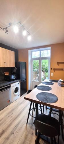 a kitchen with a table and four chairs in a room at La maison GUILLAUME in Falaise