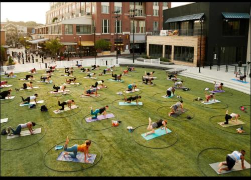 a group of people doing yoga in the grass at Grand 3br loft in Atlantic Station in Atlanta