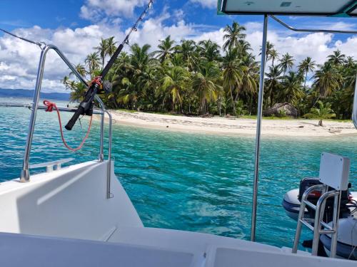 a boat in the water with a beach in the background at Catamaran in San Blás Islands, private boat in Waisalatupo