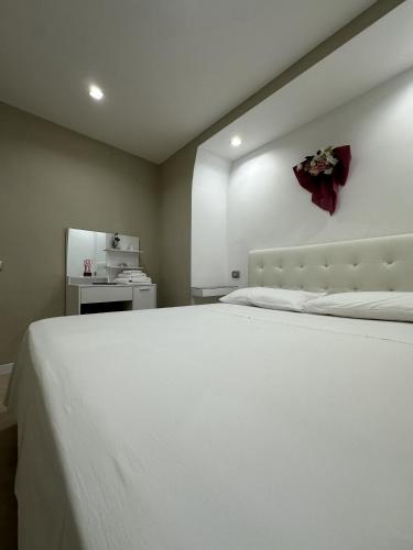 a bedroom with a white bed with a red bow on the wall at Casetta del Granatello in Portici