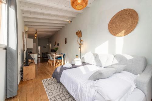 - une chambre avec un lit blanc et un salon dans l'établissement Le Bougainvillier Menton Vieille Ville, à Menton