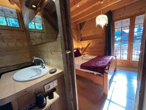 a bathroom with a sink in a log cabin at Chalet Ski-In Plagnat, Ardent in Montriond
