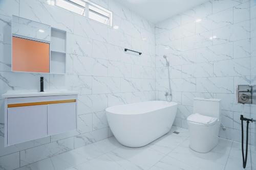 a white bathroom with a toilet and a sink at Pink Cabana Hotel in George Town