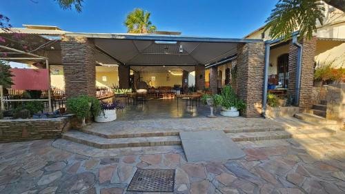 an outdoor patio with tables and chairs and plants at Bahnhof Hotel Usakos in Usakos