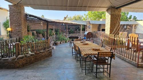 an outdoor patio with tables and chairs and a grill at Bahnhof Hotel Usakos in Usakos