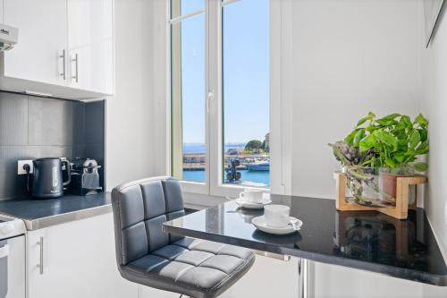une cuisine avec une table et des chaises et une fenêtre dans l'établissement Sunlight Properties - Capitaine 54 - 1 Bedroom, stunning holiday rental apartment with balcony and port view, à Nice