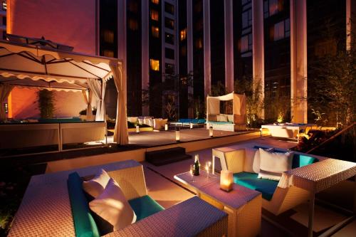 a rooftop patio with tables and chairs at night at Regal Kowloon Hotel in Hong Kong