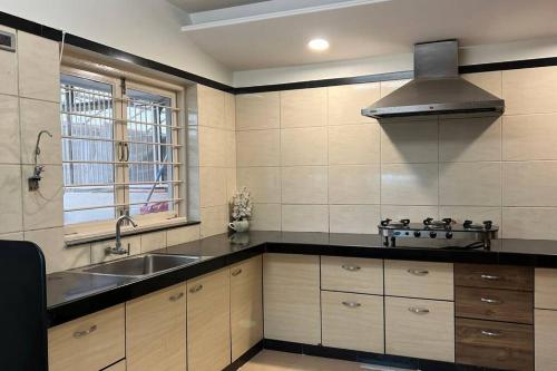 a kitchen with a sink and a stove top oven at Super Luxury Villa - Near to Karnavati Club in Ahmedabad