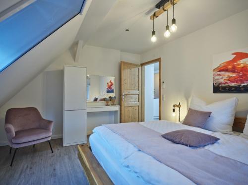 a bedroom with a large bed and a chair at Restaurant Broadmoar Appartments in Muttendorf