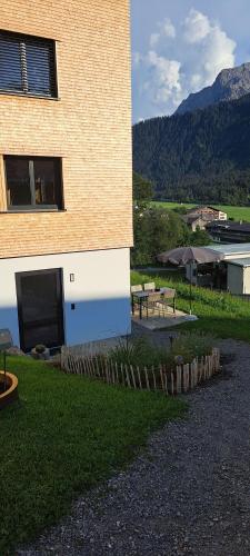 a building with a table and benches in front of it at Ferienwohnung BergTraum in Schoppernau