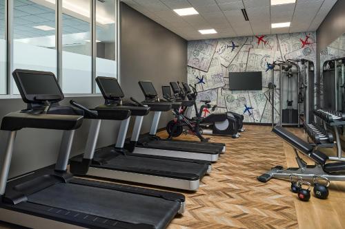 a gym with tread machines and a wall with a mural at Hyatt Place Pena Station/Denver Airport in Denver