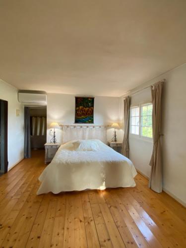 a bedroom with a large white bed and wooden floors at HELLO 15 personnes Draguignan in Draguignan