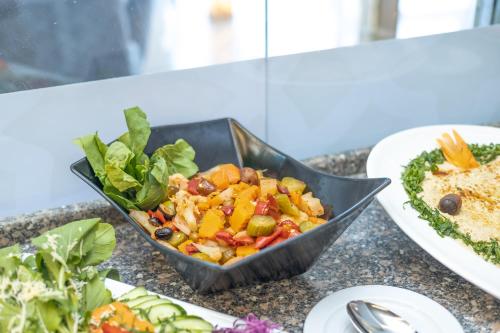 a bowl of food on a table with a salad at New Comfort Inn Giza in Cairo