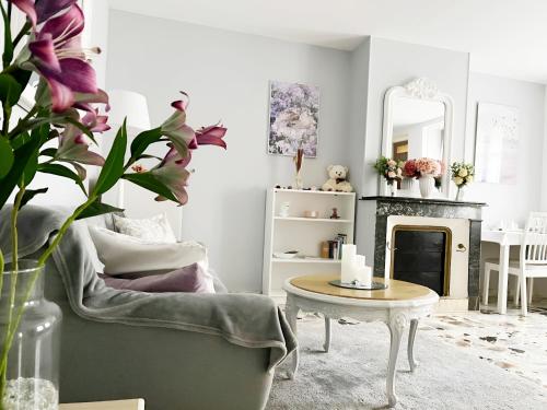 FlagyにあるMaison de village - Suite Baroque cosy et élégante à 1 h de Paris proche Fontainebleauのリビングルーム(暖炉、椅子、テーブル付)