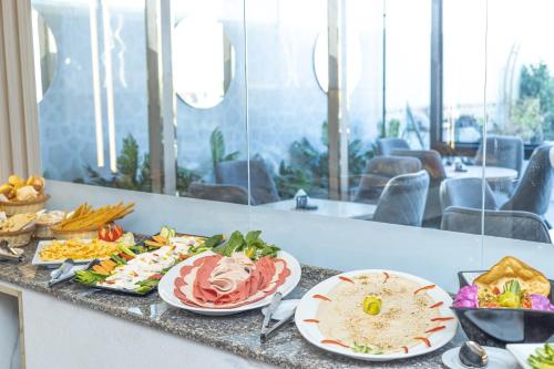 a buffet with plates of food on a counter at New Comfort Inn Giza in Cairo