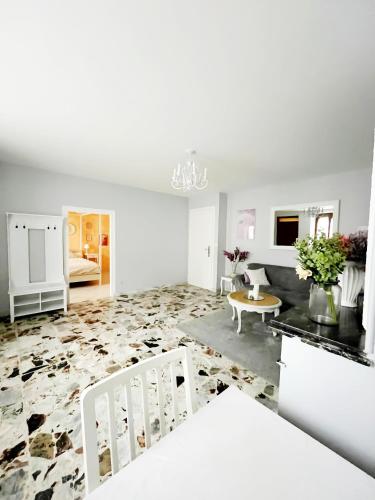 un salon blanc avec un canapé et une table dans l'établissement Maison de village - Suite Baroque cosy et élégante à 1 h de Paris proche Fontainebleau, à Flagy