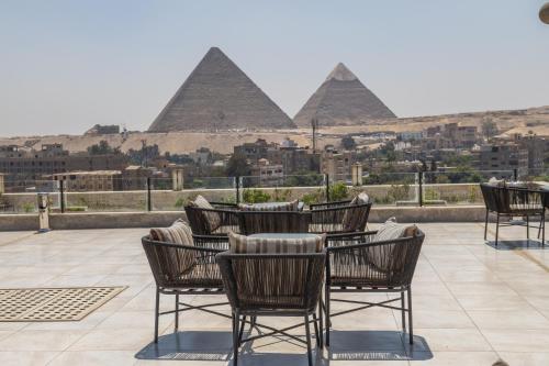 a group of chairs and tables in front of pyramids at New Comfort Inn Giza in Cairo