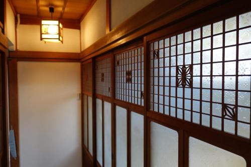 a hallway with glass doors and a light fixture at いろどり荘 ドッグラン併設 露天風呂付き in Inokuchi
