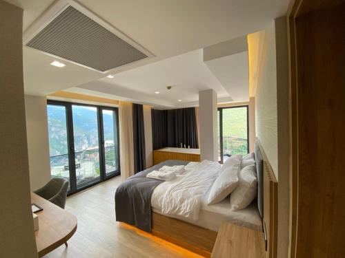 a bedroom with a large bed with white sheets and pillows at Ladur Resort Otel in Trabzon