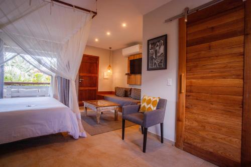 a bedroom with a bed and a chair and a window at Pousada Mi Secreto in São Miguel do Gostoso