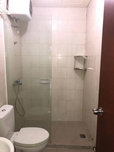 a bathroom with a shower with a toilet and a sink at Thamrin Residence City Home in Jakarta