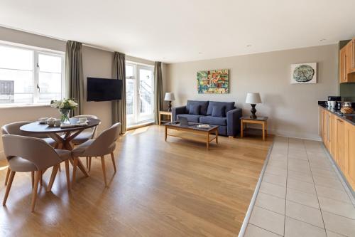 a living room with a table and a blue couch at Marlin Apartments Commercial Road - Limehouse in London