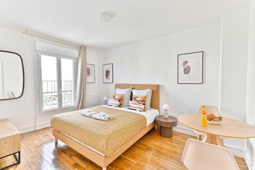une chambre blanche avec un lit et une table dans l'établissement Studio fashion Proche Métro #Paris #Montreuil - II, à Montreuil