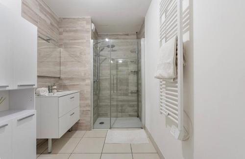 une salle de bain blanche avec une douche et un lavabo dans l'établissement Amédée Saint Germain, à Bordeaux
