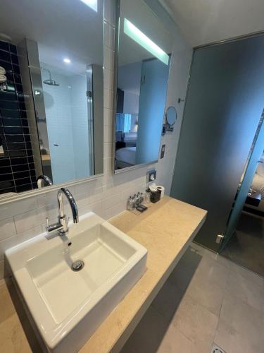 a bathroom with a sink and a large mirror at Absolute Hotel Limerick in Limerick