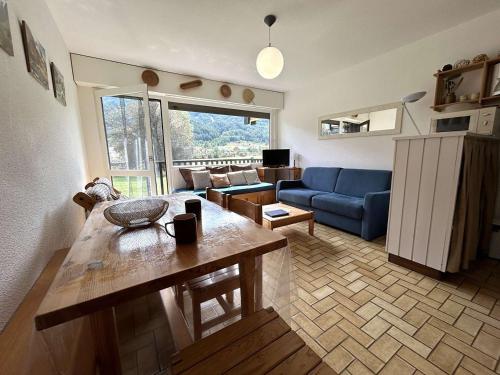 un salon avec une table et un canapé bleu dans l'établissement Studio au calme, 4 pers, proche pistes, balcon sud, parking privé, Monêtier-les-Bains - FR-1-330F-78, au Monêtier-les-Bains