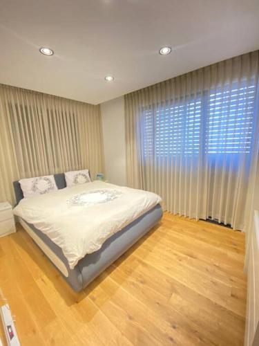 a bedroom with a bed and a large window at Villa on the beach in Netanya