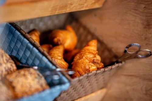 a basket full of bread and a pair of scissors at Sapia Hotel Rheinsberg in Bad Säckingen