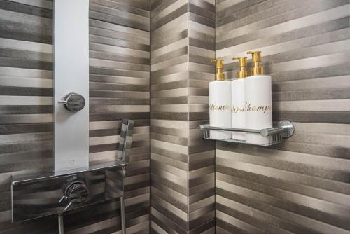 a bathroom with a shower with two towels on a wall at Aquamarine - Beach Flat in Itea