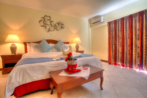 a bedroom with a bed and a table with a toy on it at Cara Hotels Trinidad in Claxton Bay