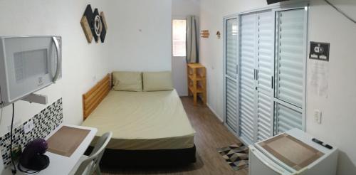 a small room with a bed and a tv at Suíte Independente - Praia Indaiá e Riviera - MarDoceLar Bertioga in Bertioga