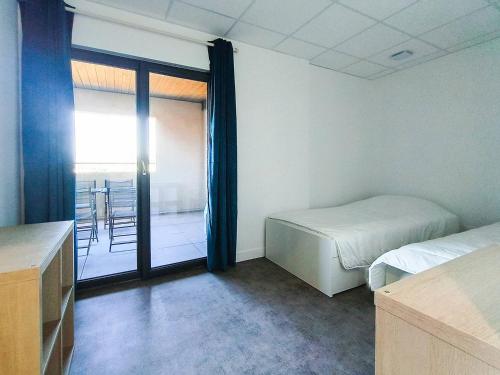 Cette chambre comprend 2 lits et une porte coulissante en verre. dans l'établissement La Gaufrette, à Ampuis