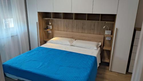 a bedroom with a bed with a blue and white blanket at Casa Marconi piano terra in Pisogne
