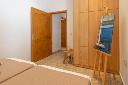 a bedroom with a bed and a painting on a table at Skali Retreat in Atsoupádhes