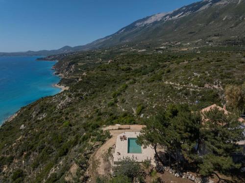 a house on a hill next to the ocean at Skali Retreat in Atsoupádhes