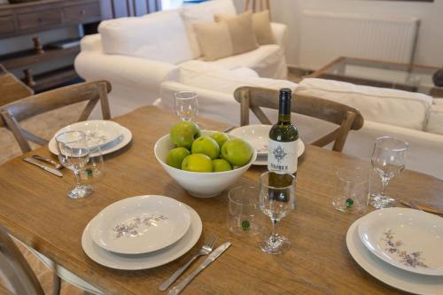 a table with a bottle of wine and a bowl of fruit at Skali Retreat in Atsoupádhes