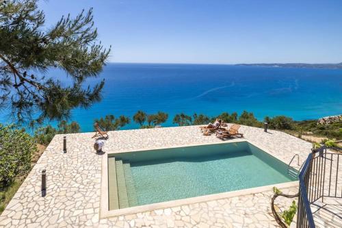 a swimming pool with a view of the ocean at Skali Retreat in Atsoupádhes