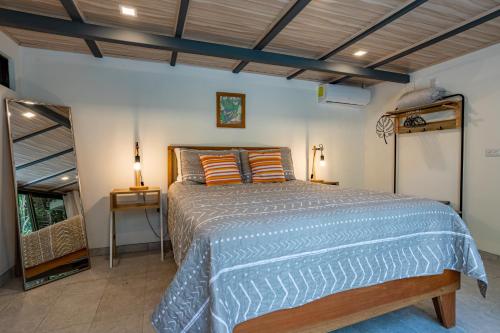 a bedroom with a bed with a blue comforter at Casa Serena - Tranquil Jungle Gem Near the Beach in Uvita