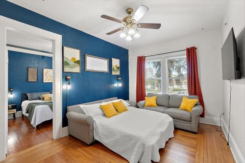 a living room with a bed and a couch at Downtown Den-King Bed~Heart of Eustis~Queen Sleeper~Upstairs~Bright & Happy in Eustis