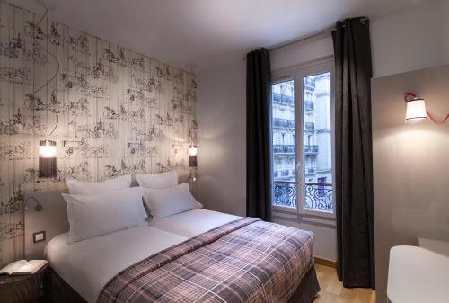 a bedroom with a bed and a window at Le Mireille in Paris