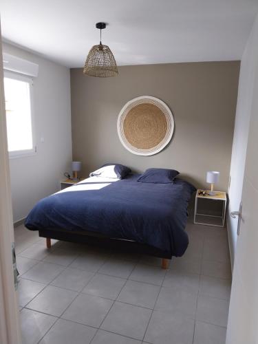 une chambre avec un lit avec une couverture bleue dans l'établissement Logement des Bruyères, à Wardrecques