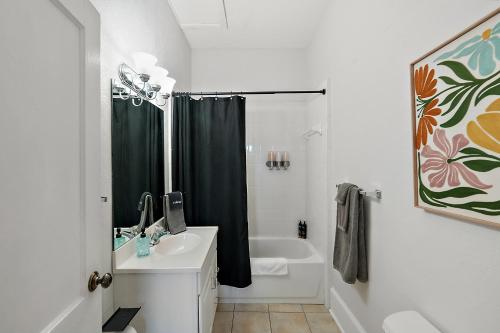 a bathroom with a black shower curtain and a sink at Downtown Den-King Bed~Heart of Eustis~Queen Sleeper~Upstairs~Bright & Happy in Eustis